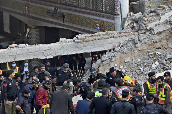 Güvenlik görevlileri ve kurtarma ekipleri, Peşaver'deki intihar saldırısı alanında ceset arıyor.