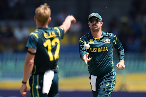 Australia’s captain Travis Head, right, throws a ball.