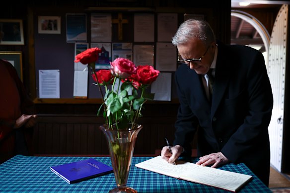 Le Premier ministre Anthony Albanese signant le livre des visiteurs à l'église Crathie Kirk en Écosse.