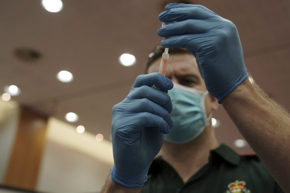 A healthcare worker fills a syringe with the AstraZeneca vaccine.