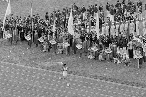Soviet athlete Sergei Belov runs with the Olympic flame past the Olympic team from Afghanistan during opening ceremonies of the 1980 Summer Olympic Games in Moscow.