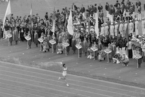 Soviet athlete Sergei Belov runs with the Olympic flame past the Olympic team from Afghanistan during opening ceremonies of the 1980 Summer Olympic Games in Moscow.