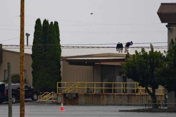 Two FBI investigators scan the roof of the building from which shooter Matthew Thomas Crooks fired at Donald Trump.