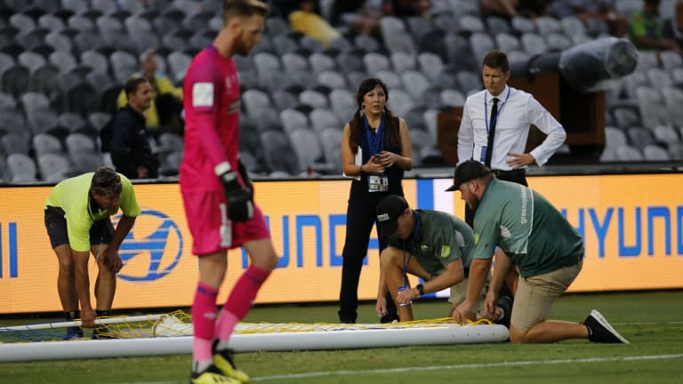 Fruitless: Workers try to fix the damaged goalpost before replacing it altogether.