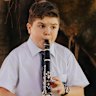 Year 7 student Luca Squire playing his clarinet in the Botanic Gardens, which borders the school.