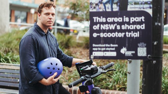 Inner West Greens councillor Dylan Griffiths on a Beam e-scooter outside Kogarah train station.