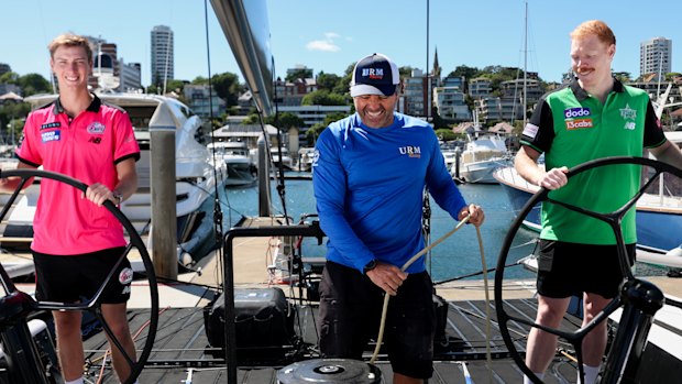 Sydney Sixers Lachie Shaw, left, and Melbourne Stars Liam Hatcher, right, with boat captain of URM Group.