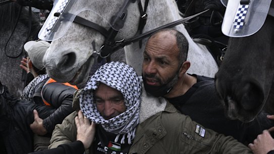 Two protesters clash with police at the anti-war protest in Melbourne.
