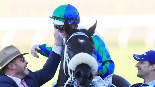 Trainer Peter Moody greets Luke Nolan as he returns on  I Wish I Win after winning the Golden Eagle..