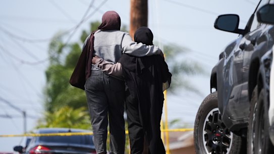 Two women embrace near the scene of the San Diego shooting.