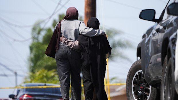 Two women embrace near the scene of the San Diego shooting.