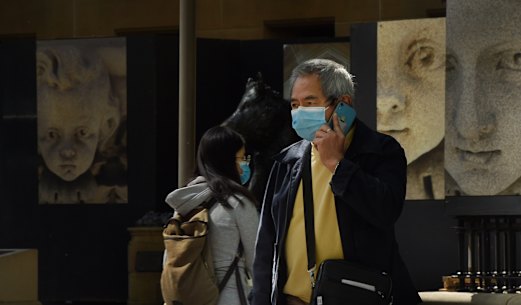 A man wearing a face mask to prevent catching COVID-19 crosses Macquarie Street in the city. Sydney, NSW. Coronavirus COVID-19. 28th September, 2020. Photo: Kate Geraghty 