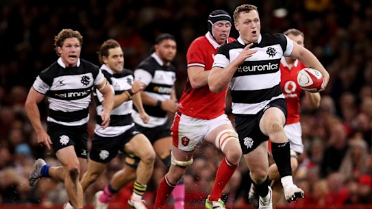 Angus Bell runs the ball before kicking for a try assist.