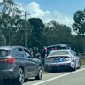 Two cars, believed to have been stolen, with a police car on the side of a road near Townsville in north Queensland, April 6, 2026.