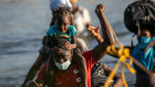 A girl rides on her father’s shoulders as they cross the Rio Grande to collect supplies for a migrant camp in Ciudad Acuna, Mexico. 