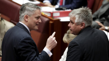 Minister for Finance Mathias Cormann in discussion with Senator Rex Patrick in the Senate. 