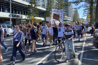 Protestors marched down the Esplanade at Coolangatta before congregating at the NSW border on Sunday