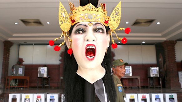 A giant effigy locally known as "ogoh-ogoh" is displayed at a polling station to ward off evil spirits in Bali, Indonesia.