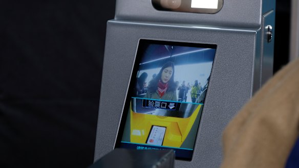 Facial recognition technology at a train station in China, where commuters are scored on their behaviour for a national "social credit" system.