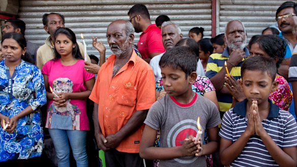 People pray during a nationwide three-minutes silence as a tribute to Easter Sunday attack victims.