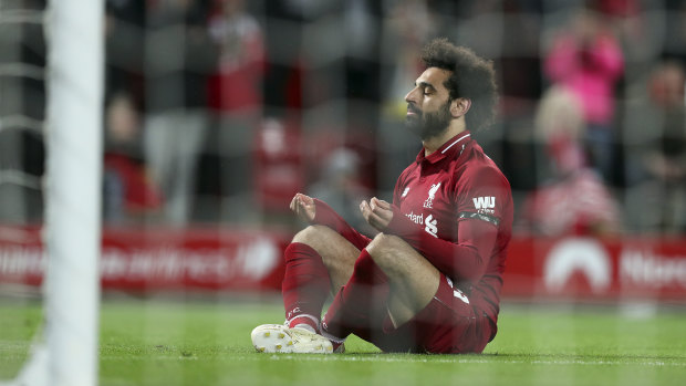 Liverpool's Mohamed Salah takes a moment after scoring their fifth goal against Huddersfield.
