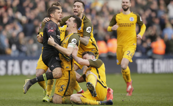 Brighton players swamp Mat Ryan after the keeper's penalty shootout heroics.