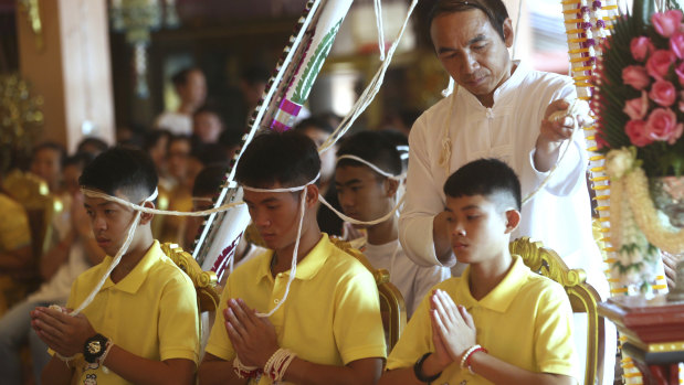 Ekaphol 'Ake' Chantawong, centre, and members of the rescued soccer team attend a Buddhist ceremony believed to extend the lives of its attendees as well as ridding them of dangers and misfortunes in Mae Sai, Chiang Rai province, northern Thailand, on Thursday.