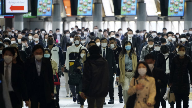 A station passageway is crowded with commuters wearing face mask during rush hour in Tokyo on Monday.