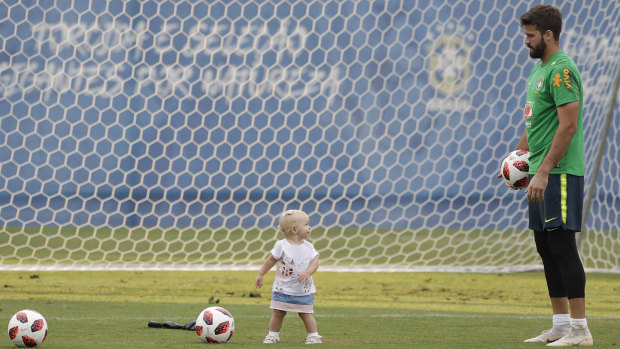 Next gen: Brazil goalkeeper Alisson plays with his daughter Helena during a training session ahead of their quarter-final clash against Belgium.