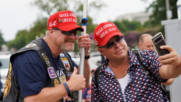 Dion Cini (right) takes a selfie with a fellow Trump supporter outside court.