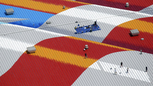 Scott LoBaido and his team paint an American flag on top of Lamons Gasket Company  in Houston. The giant flag covers 14,000 square metres.