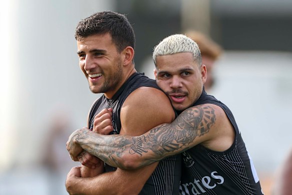 Bobby Hill embraces teammate Nick Daicos during a Collingwood training session at Olympic Park.