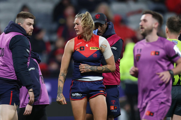 Tayla Harris of the Demons reacts and leaves the field after injuring her shoulder.