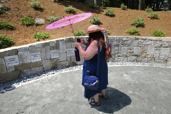Karla Hailer, a fifth-grade teacher  takes a video where a memorial stands at the site in Salem where five women were hanged as witches more than three centuries years earlier.