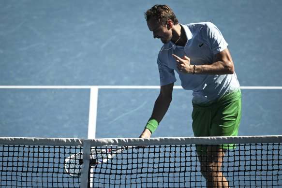 Daniil Medvedev smashes his racquet into the net on Rod Laver Arena.
