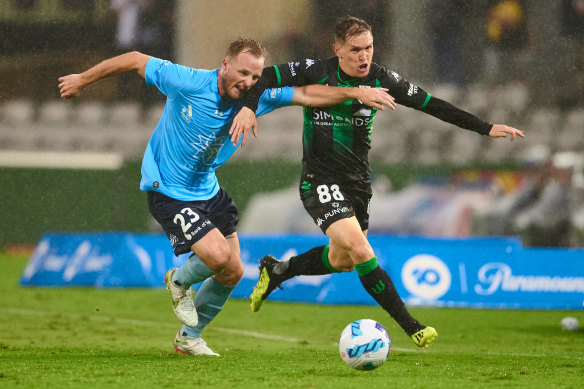 Rhyan Grant and Neil Kilkenny battle in the rain at Netstrata Jubilee Stadium.