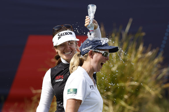 Hannah Green helps women’s winner Ashleigh Buhai get into the party spirit.