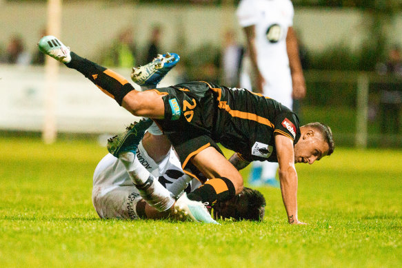 Kosta Grozos of the Wanderers and Jake Brimmer of the Glory clash during the FFA Cup at Dorrien Gardens in Perth on Wednesday night.