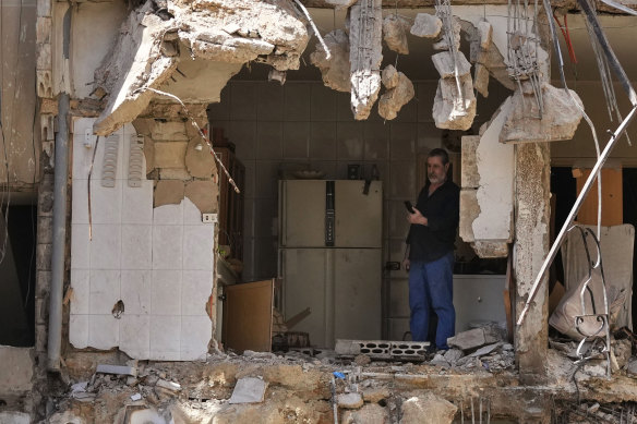 A man stands in what remains of an apartment building in Beirut’s southern suburbs following Friday’s Israeli strike on the area.