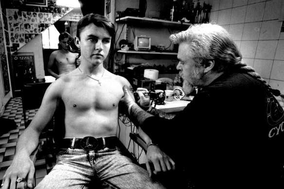 Tony Cohen from The Illustrated Man Tattoo Studio gives 18-year-old Michael Nagle a tattoo.