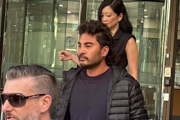 Tech billionaire Laurence Escalante (centre, in black) leaves Perth Magistrates Court on Friday.
