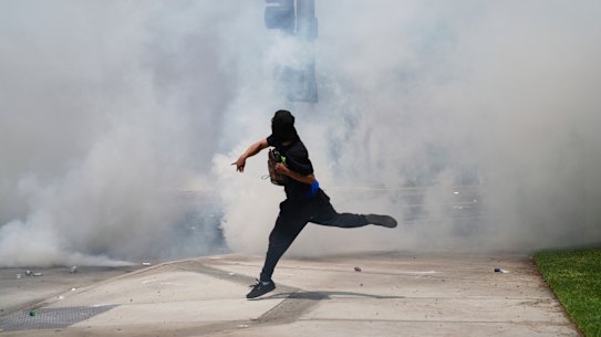 A protester in Paramount, Los Angeles, throws a rock amid tear gas from law enforcement during a demonstration after federal immigration authorities conducted operations.