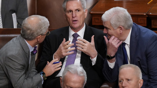 Representatives Patrick McHenry, left, and Tom Emmer, right, huddle with Kevin McCarthy in the House on Thursday (AEDT).