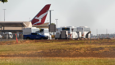 Buses wait to transport passengers from flight QF112 to Howard Springs.