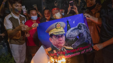 Myanmar nationals living in Thailand set fire to a picture of military leader Min Aung Hlaing during a protest outside the Myanmar embassy in Bangkok on Thursday.