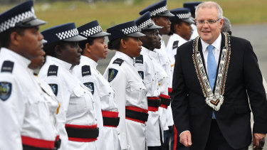 Prime Minister Scott Morrison inspects an honour guard of the Royal Solomon Islands Police Force after arriving at Honiara International Airport.