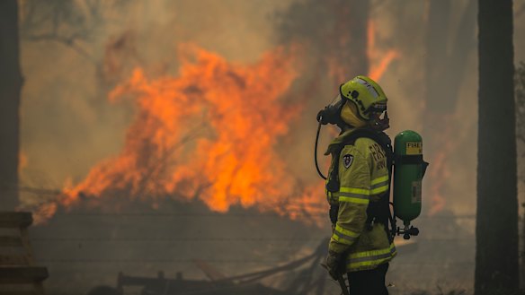 Firefighter Adam Brown protects properties along Glenthorne Road in South Taree.