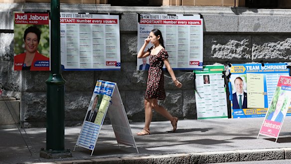 A voter walks past "how to vote" boards, in the absence of volunteers, in Brisbane.