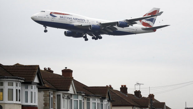 A plane approaches landing over the rooftops of nearby houses at Heathrow Airport in London.