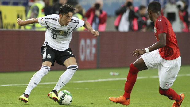 Germany's Mesut Ozil (left) vies for the ball with Austria's David Alaba.
